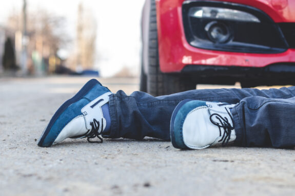 pedestrian laying in front of car